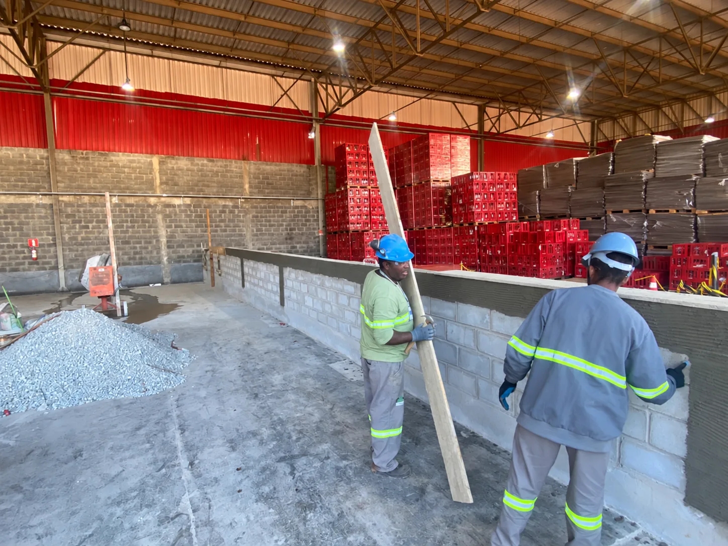 Colaboradores executando pequena obra civil com equipamentos de proteção