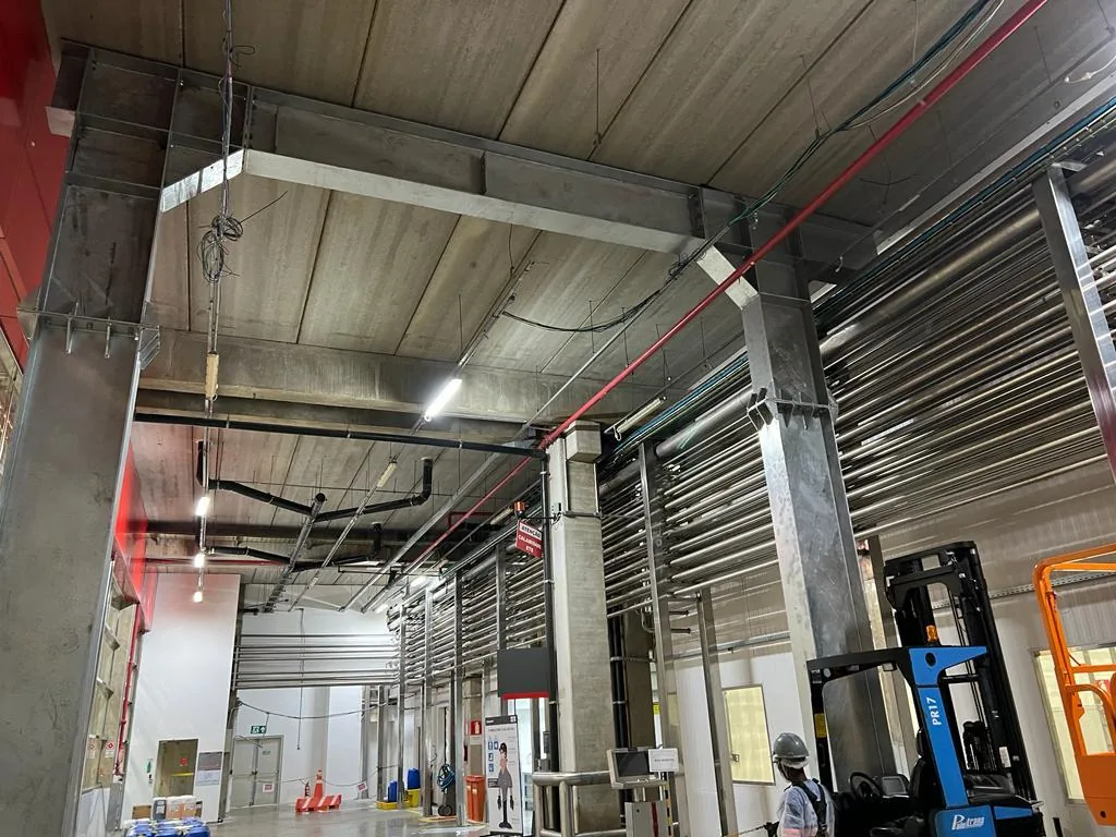 Área industrial com instalações, tubulações e equipamentos em operação